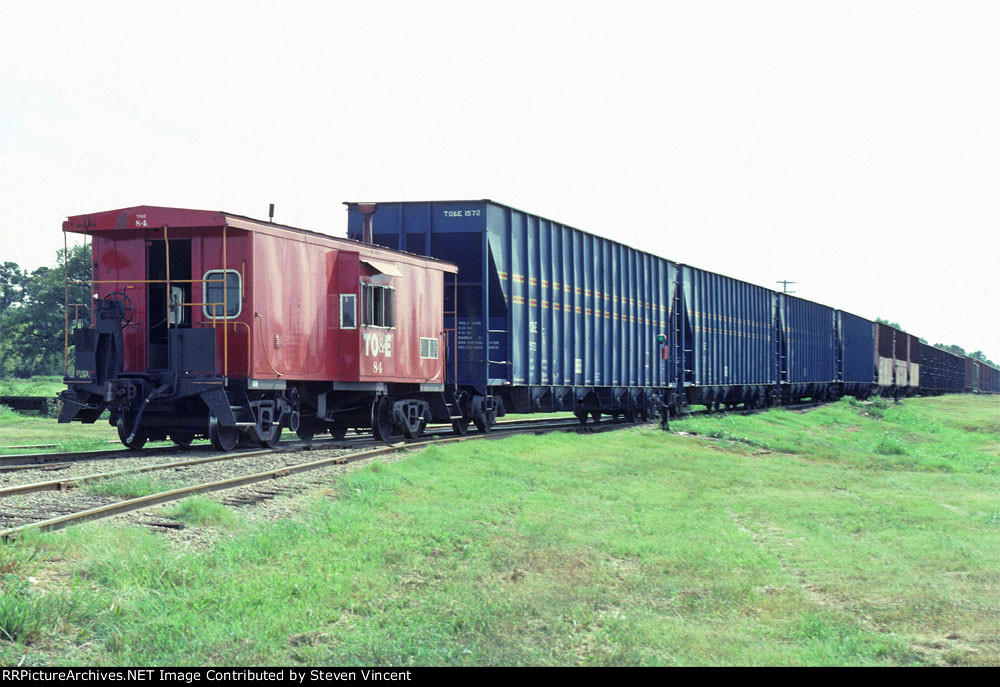 Texas Oklahoma & Eastern bay window caboose #84 on woodchip train.